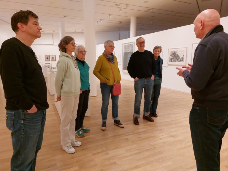 Udo Achterhold führt Besucher durch die Ausstellung Grafik im Dialog.